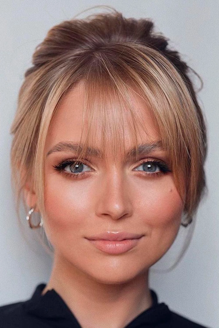 Casual Makeover Tip: Simple Clip in Bangs for Effortless Styling Woman with bangs and a simple clip achieving an easy casual makeover hairstyle