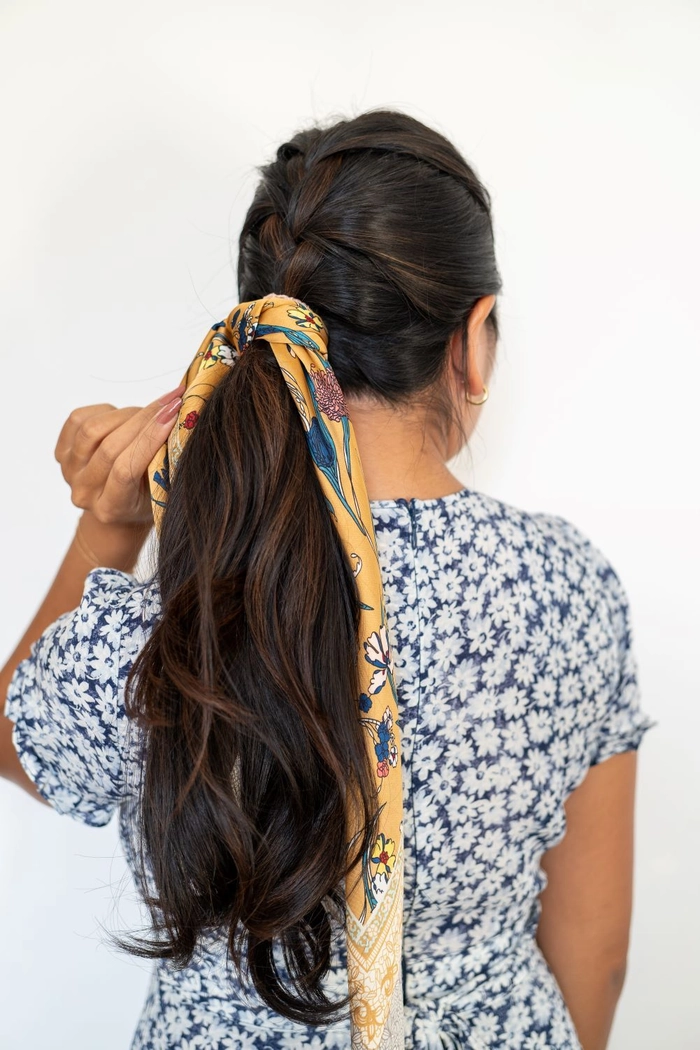 Woman wearing a casual scarf hairstyle to protect hair in winter outdoors
