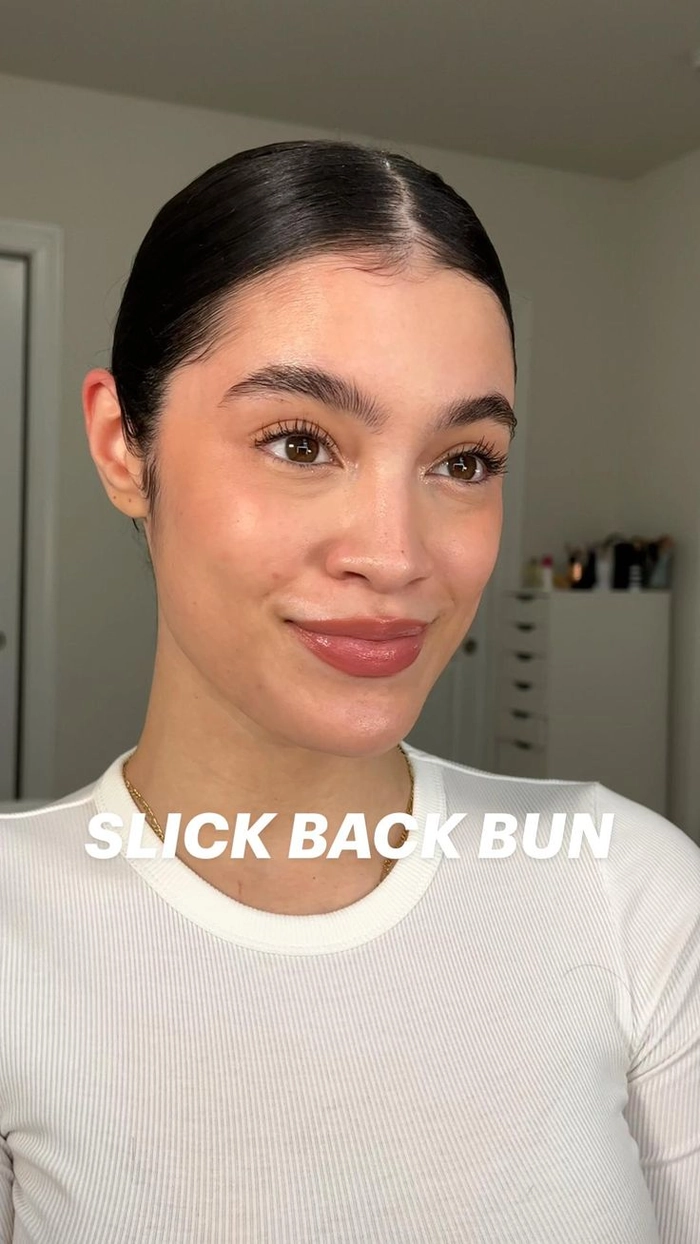 Woman with curly hair styled in an effortless slicked back bun for a casual look