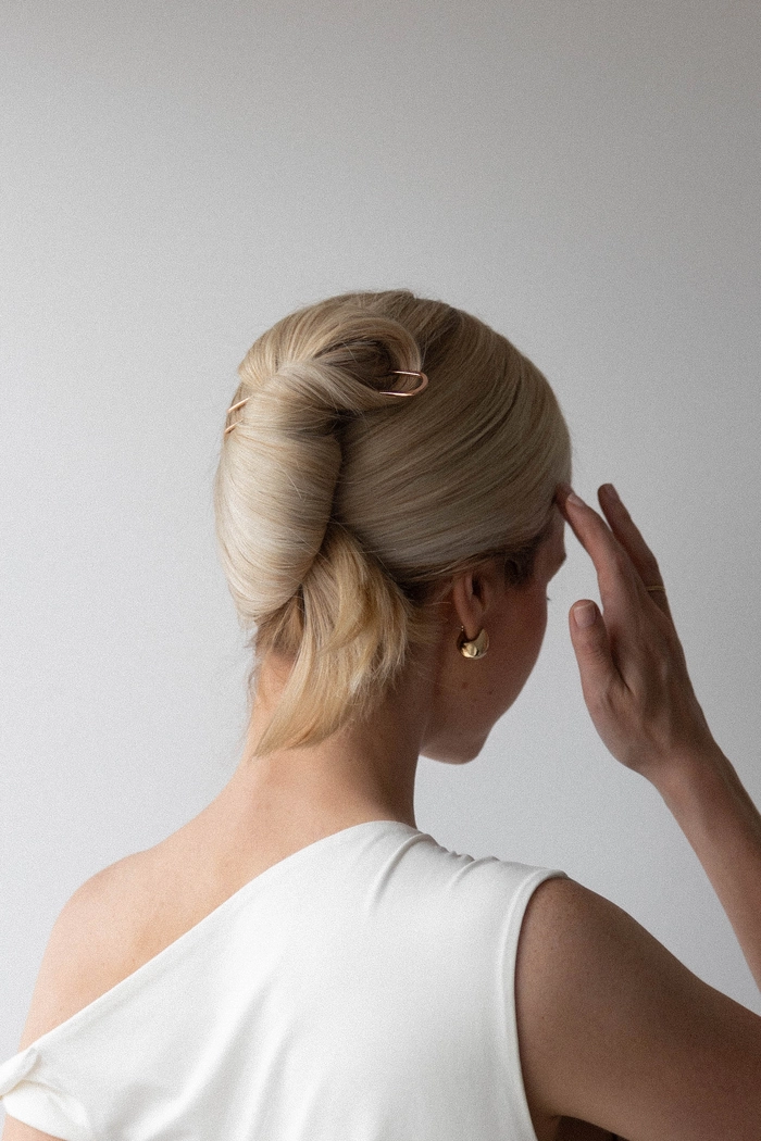 Effortless elegance with a casual French barrette updo hairstyle Woman showcasing simple French barrette updo for effortless elegance in casual hairstyle