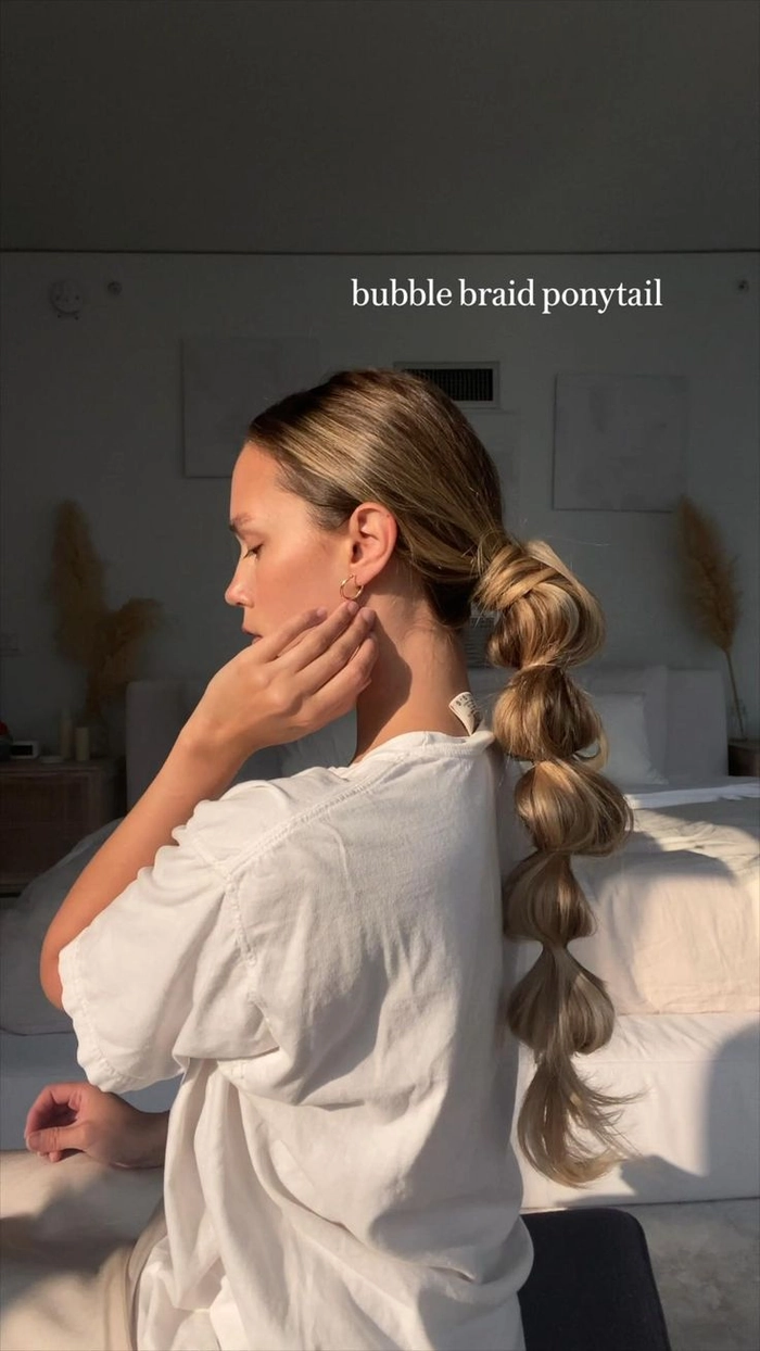Woman with long hair styled in a casual bubble braid ponytail