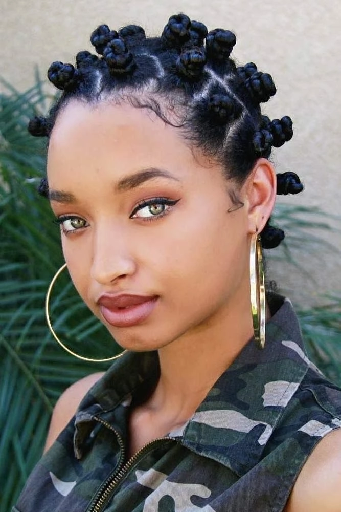 A woman with a stylish pineapple puff and silk scarf, an everyday low-manipulation style for transitioning natural hair