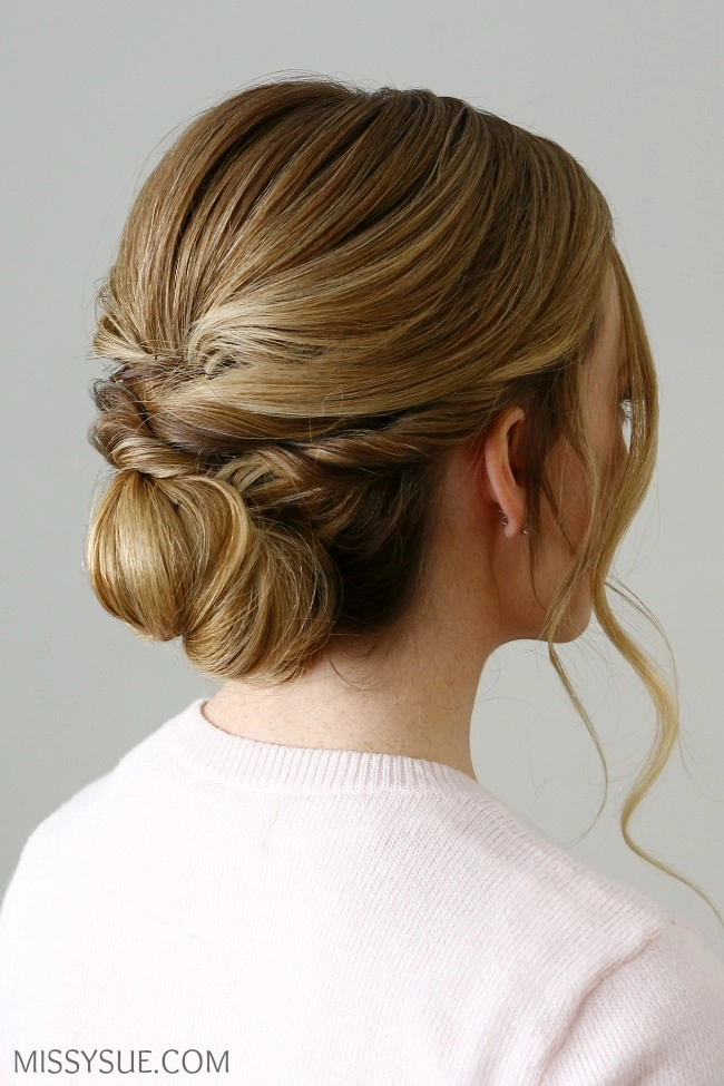 Elegant low twisted bun perfect for casual work environments and quick styling Woman with a quick low twisted bun hairstyle suitable for professional casual settings