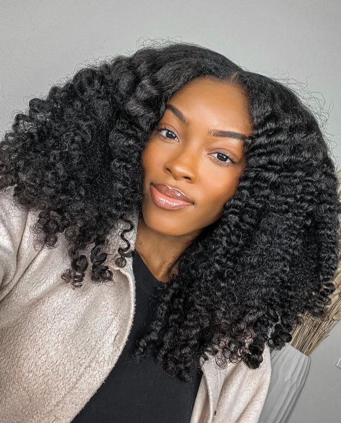Casual hairstyle inspiration featuring relaxed braid out on natural coils number 8 Woman with relaxed braid out hairstyle showcasing natural coils for a casual look