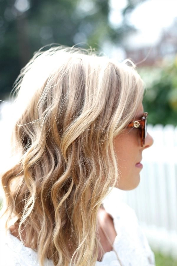 Casual hairstyle showcasing relaxed loose curls for medium length hair Woman with relaxed loose curls for medium length hair in a casual setting
