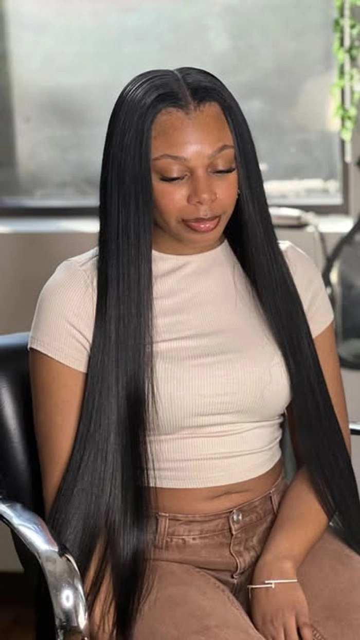 Woman with long straight hair wearing a simple middle part, casual everyday look