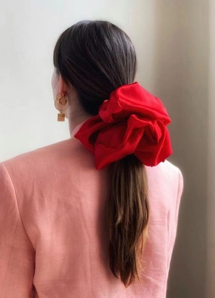 Young woman showing quick scrunchie hairstyles for 90s casual aesthetics in casual outfit