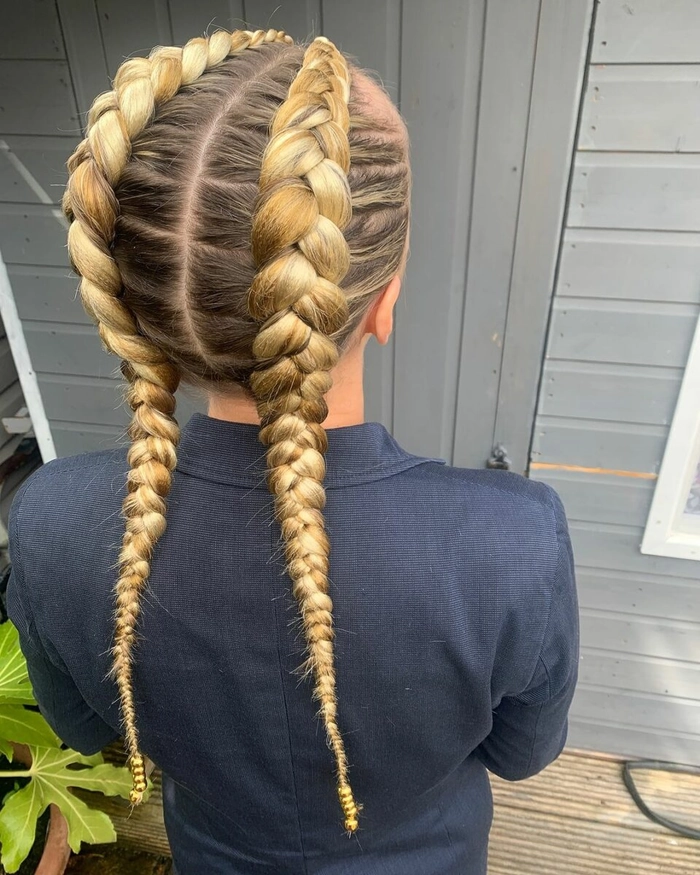 Casual double braids hairstyle perfect for sports and active days Young woman with casual double braids styled for athletic activities outdoors