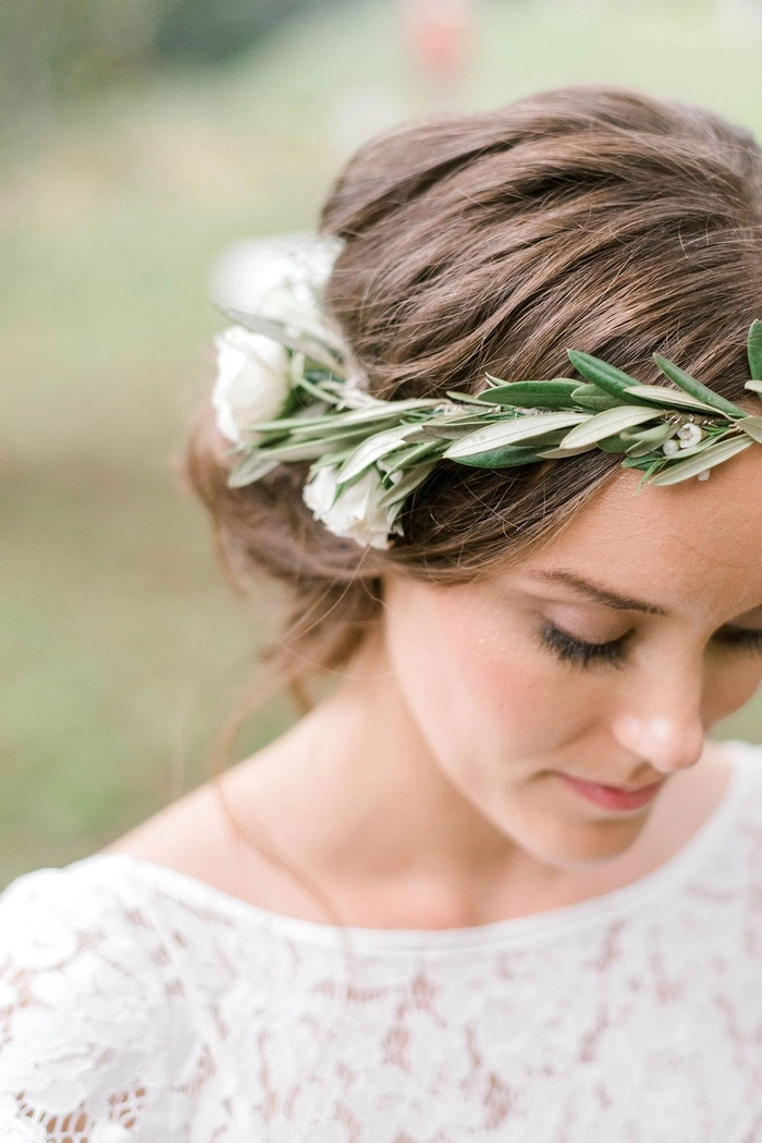 Boho chic braided crown hairstyle perfect for romantic date nights in nature A woman wearing a boho chic braided crown with flowers, smiling on an outdoor date