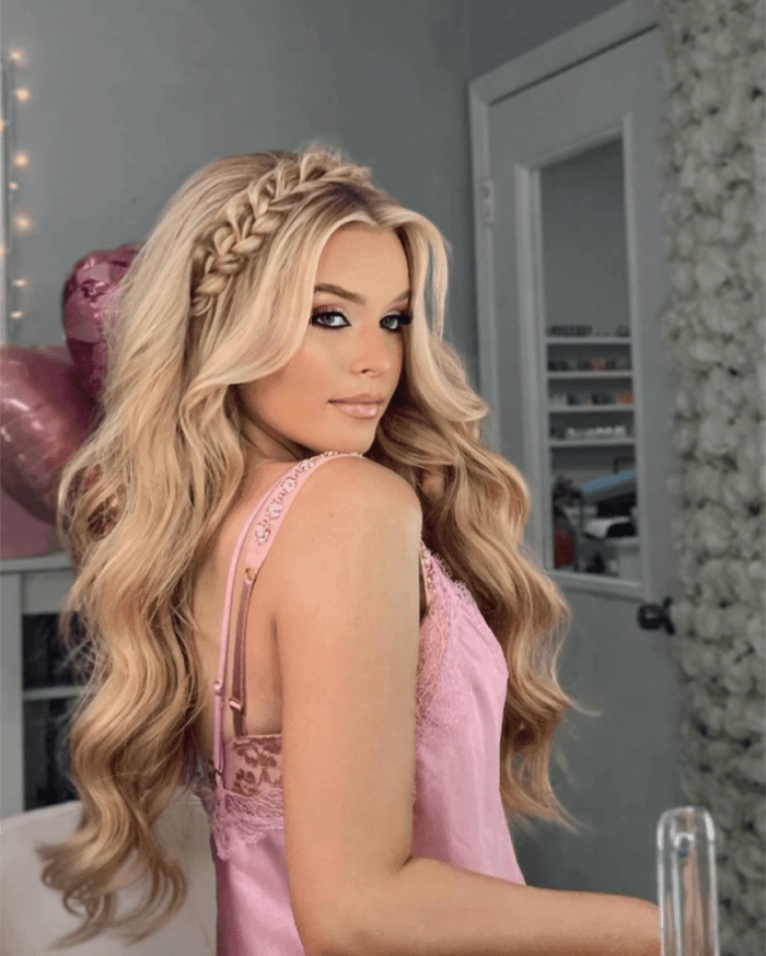 Long dark hair woven into a romantic side braid with soft waves for date night