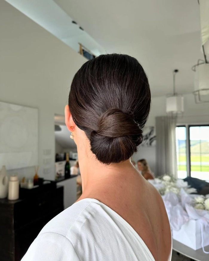 Elegant low bun hairstyle perfect for formal date nights Woman with a polished classic low bun at an upscale dinner setting