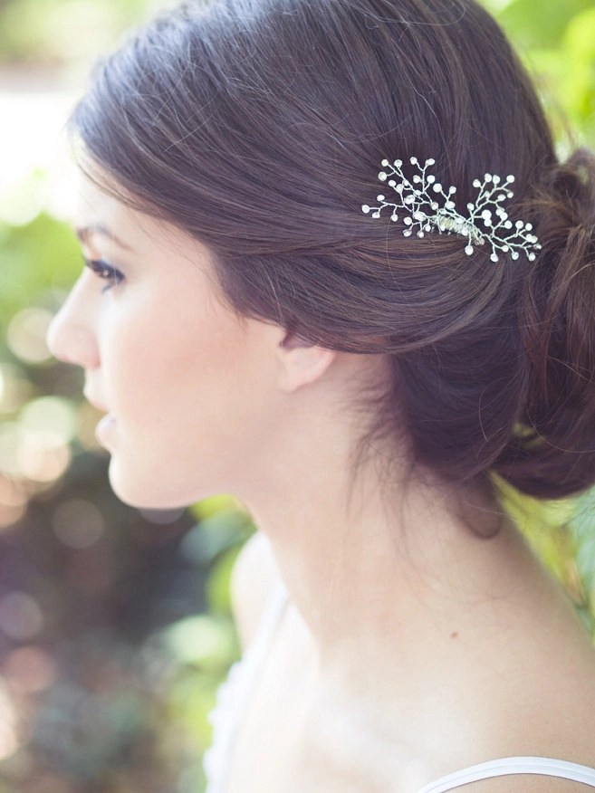 Elegant updo hairstyle adorned with vintage brooches for a romantic date night look