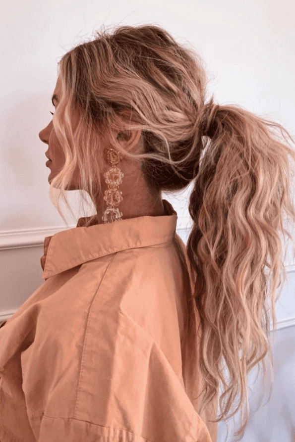 A woman's shoulder-length hair styled in a half-up twisted bun with soft tendrils for a date night look