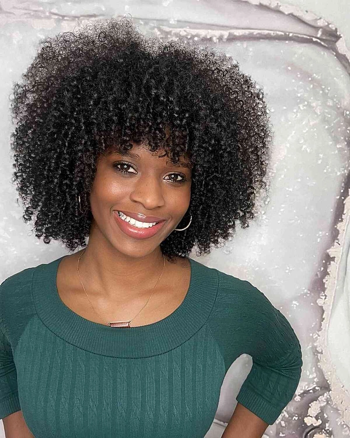 Black woman with natural hair styled in a curly half-up half-down date night look