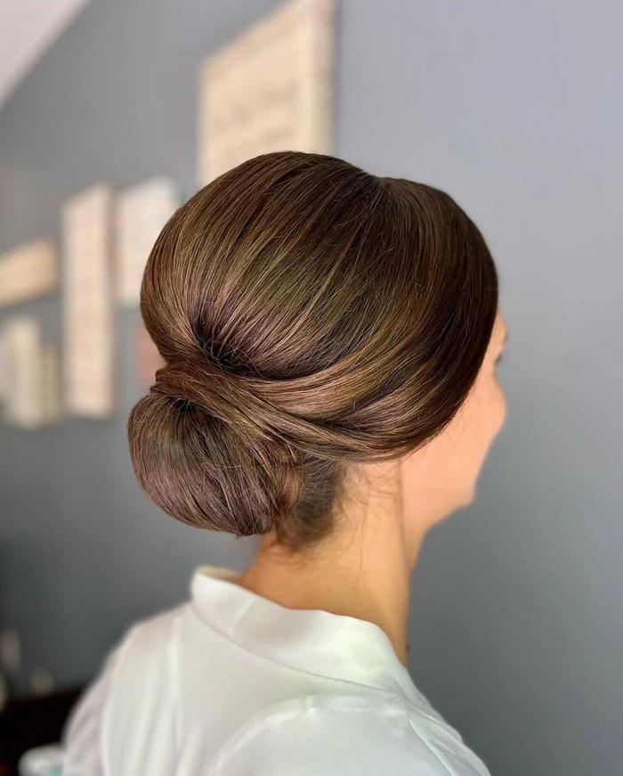 A woman with bangs shows off a romantic, softly curled date night hairstyle