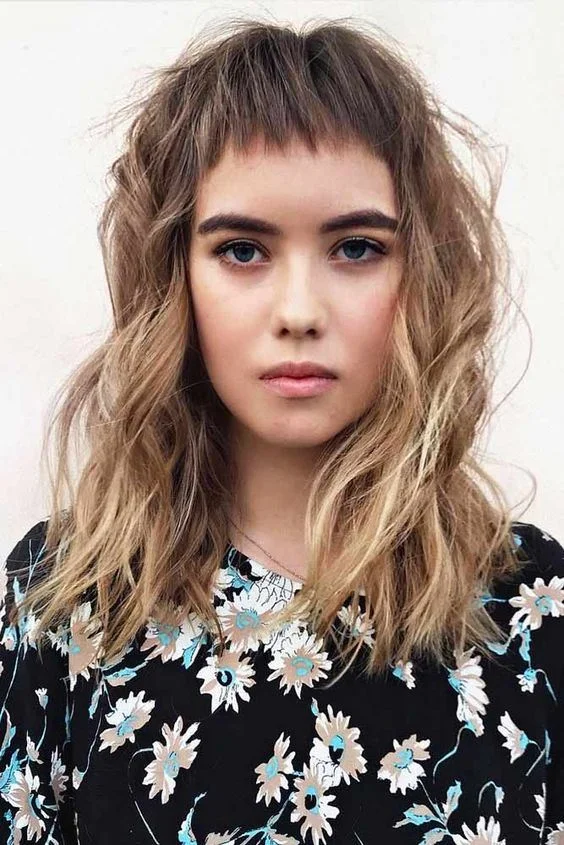 Chic date night updo featuring trendy micro bangs with soft face-framing pieces