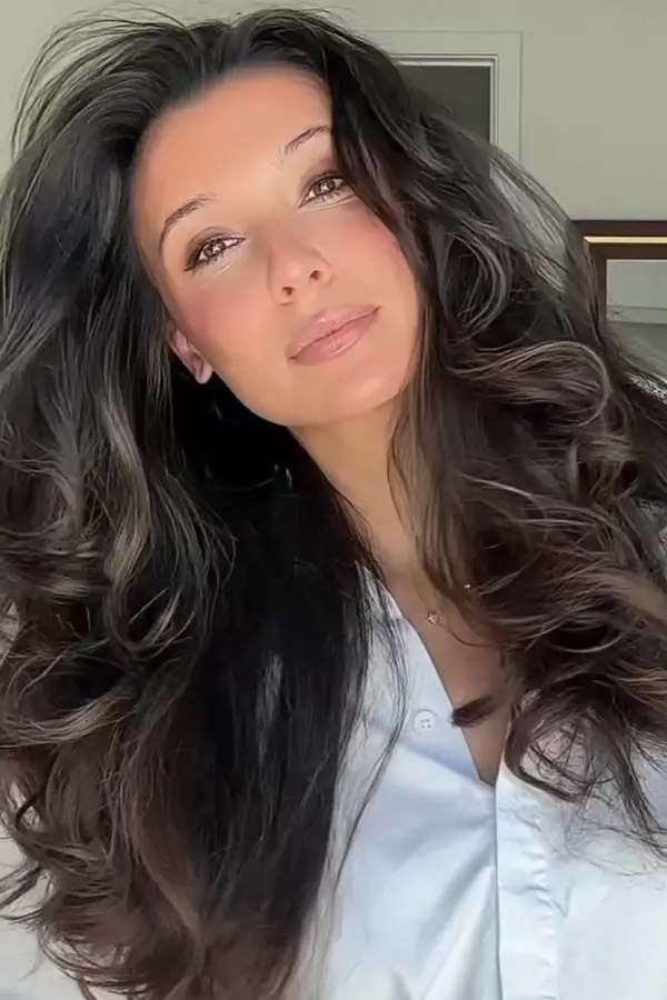 Woman with fine hair styled into a voluminous blowout for a date night look