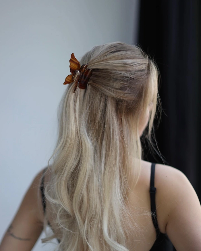 Elegant half up hairstyle secured with a claw clip for a romantic date night look