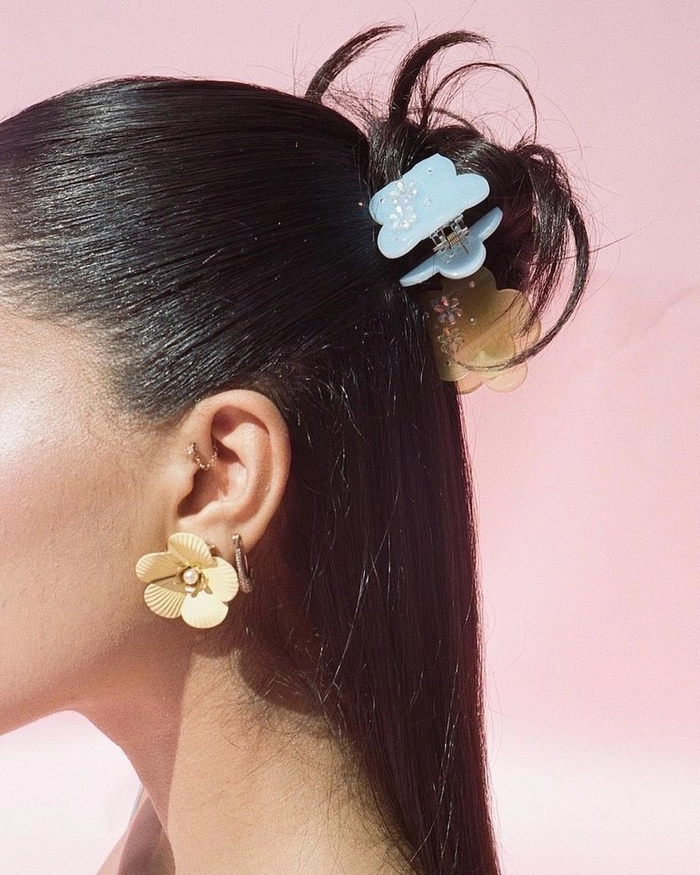 A romantic half up hairstyle fastened with a decorative claw clip, ideal for date night