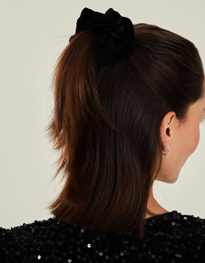 Elegant evening hairstyle featuring a soft velvet scrunchie for a polished date night look Side-swept updo with black velvet scrunchie for romantic date night hair