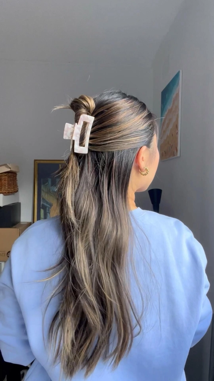 Half up hairstyle elegantly secured with a claw clip for a romantic date night look