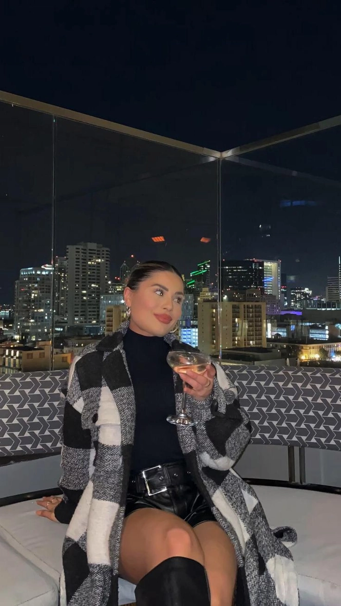 Wind-resistant hair perfect for a stylish rooftop date night A couple enjoying a romantic rooftop bar date with wind-resistant hairstyles