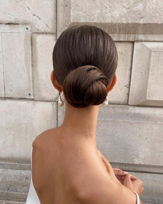 Straight hair styled in an elegant bun for a date night look