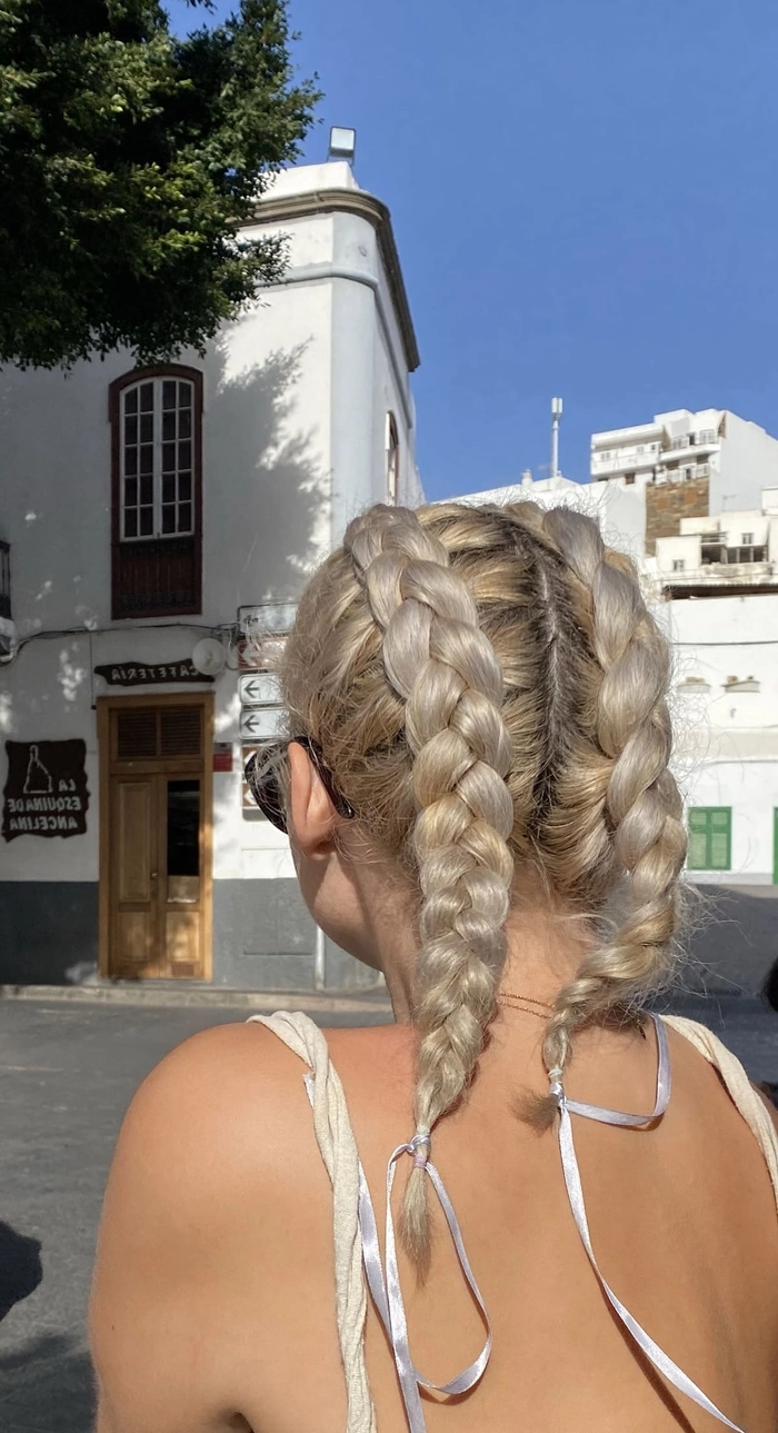 Summer concert hairstyle inspiration with soft waves and flowers Romantic braided updo for a summer outdoor concert date