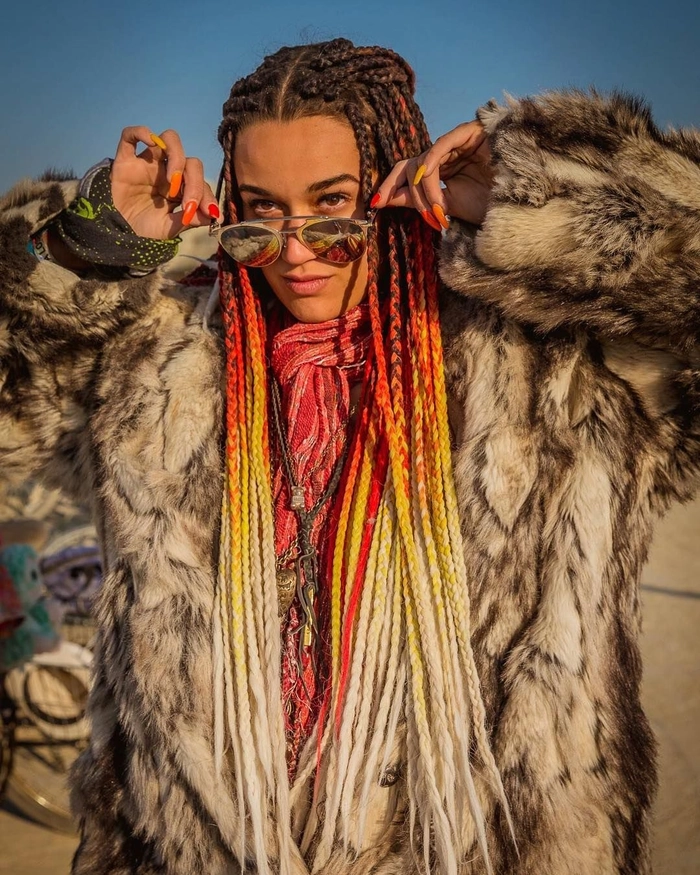Creative braided festival look for Burning Man Burning Man hairstyle featuring colorful braids and desert-inspired accessories