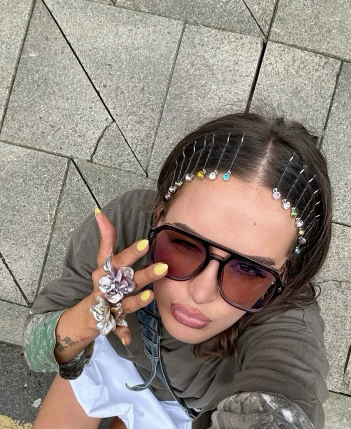 An edgy festival hairstyle with shaved patterns and bright pink accents