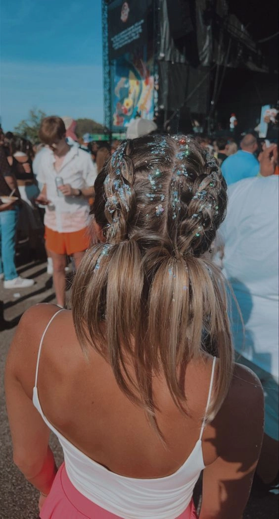 Edgy festival hairstyle with braids and metallic hair cuffs, featuring shaved sides and bold color streaks