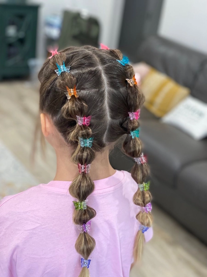 Woman with a festival bubble braid hairstyle adorned with colorful beads and ribbons