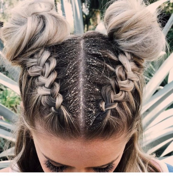 Festival bun hairstyle with braided wrap and floral accessories