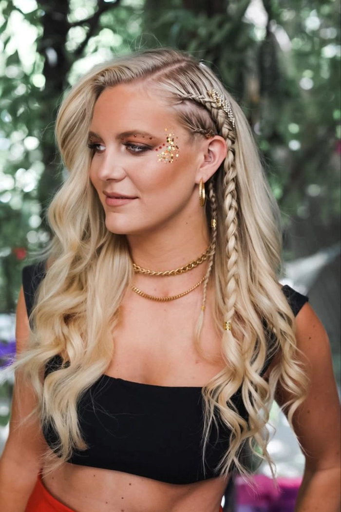 Festival hairstyle for curly hair with braids and flowers on a sunny stage