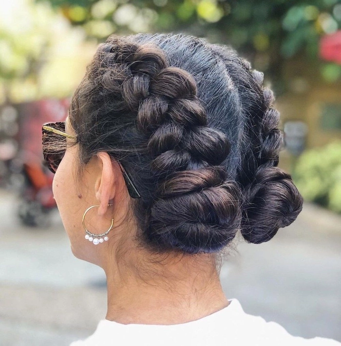 A woman with a festival Dutch braid hairstyle adorned with flowers and beads