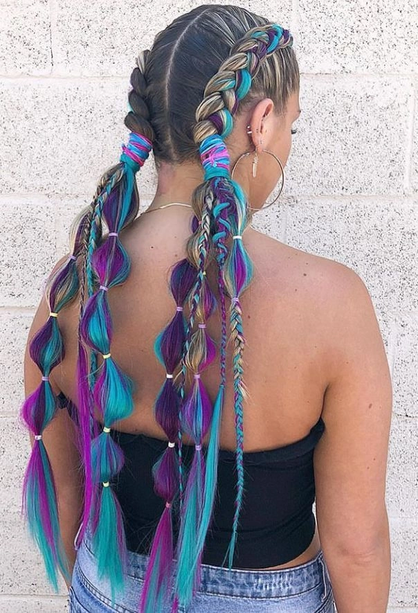 Festival Dutch braid hairstyle with colorful flowers woven into the braid