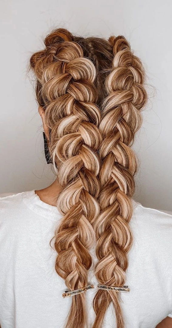 Model with a Dutch braid festival hairstyle accented with floral details