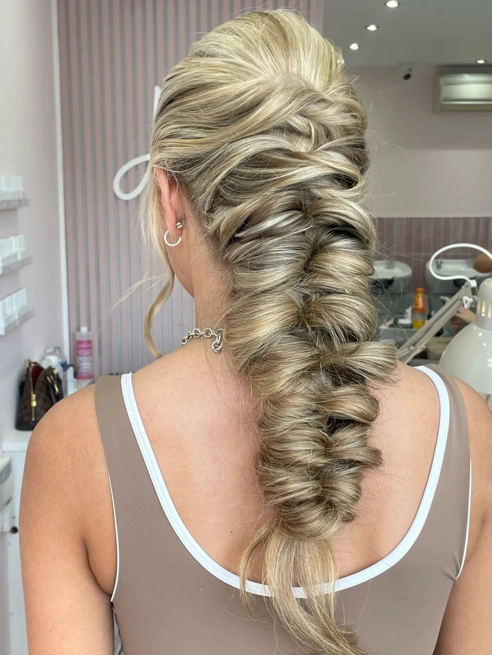 Festival fishtail braid hairstyle with colorful flowers woven through