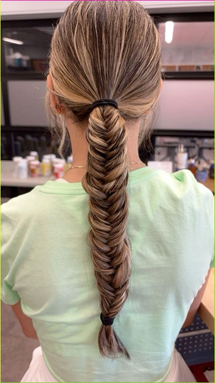 Festival fishtail braid hairstyle with floral accents and bohemian waves