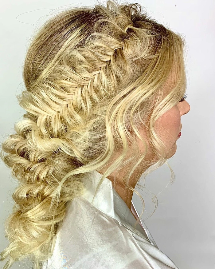 Festival fishtail braid hairstyle with delicate flowers woven into the plait