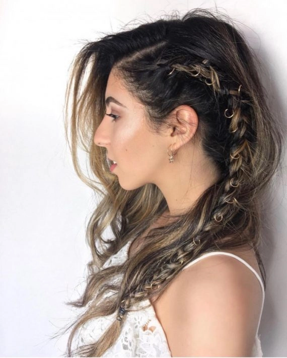 Festival French braid hairstyle with bright flowers woven through the braid