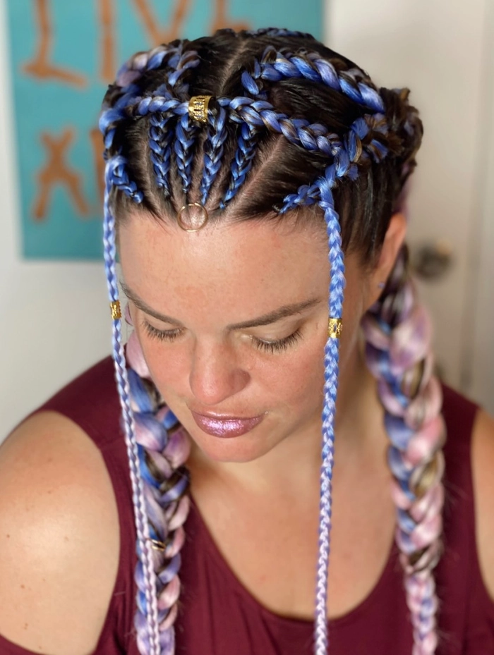 Festival French braid hairstyle accented with subtle waves and floral accessories