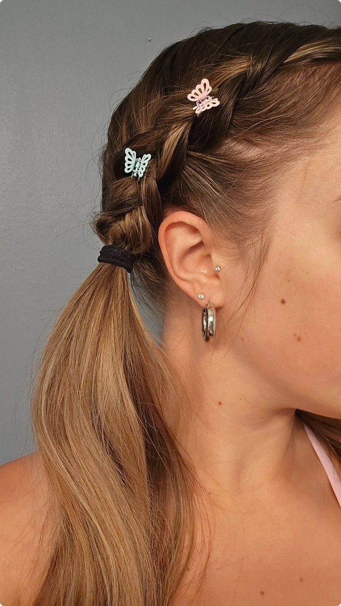 Festival hairstyle with butterfly clips adding a whimsical touch to your summer look Woman with loose waves and colorful butterfly clips pinned throughout her festival hairstyle