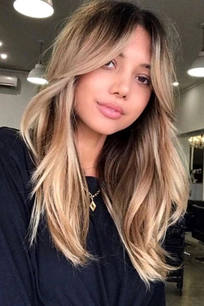 Festival hairstyle with curtain bangs and decorative flowers A festival hairstyle with curtain bangs and braided accents