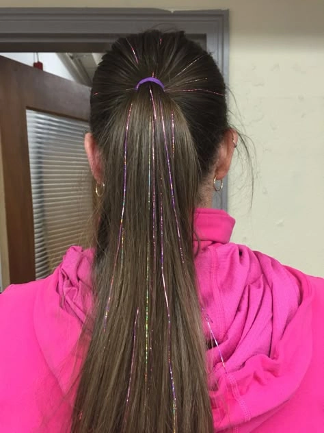 Woman with braided festival hairstyle accented with gold hair tinsel