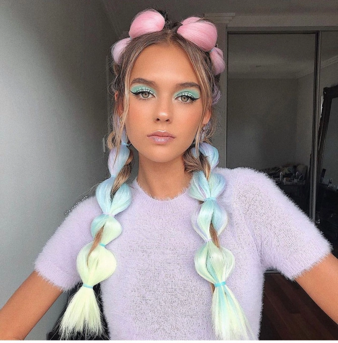 Pastel hair festival braids with floral accents Festival hairstyle featuring pastel pink and blue hair styled in braids with flowers