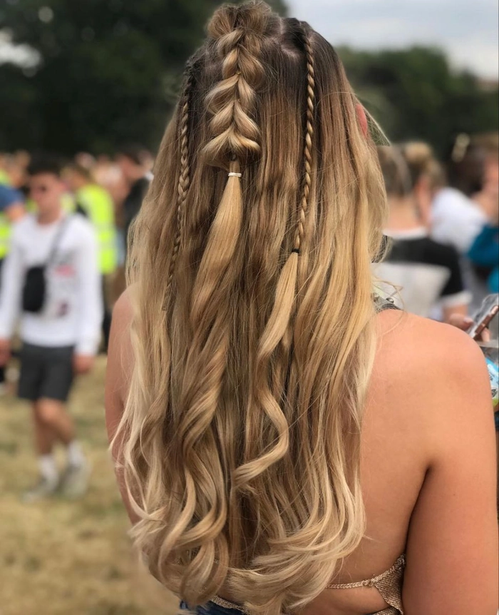 A festival hairstyle for wavy hair with braided crown and floral accents
