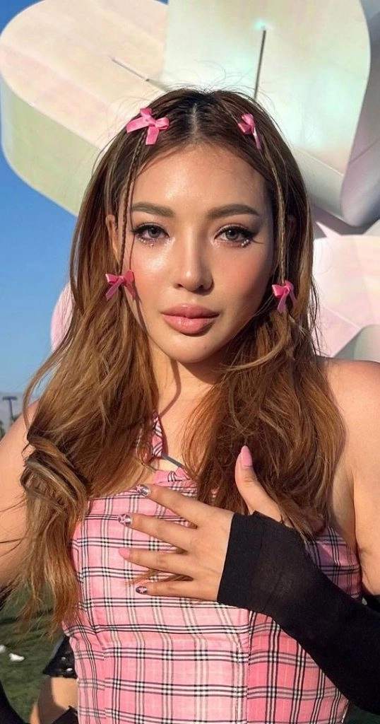 Boho festival look featuring curtain bangs and braided details Festival hairstyle with bangs and glittery hair accessories