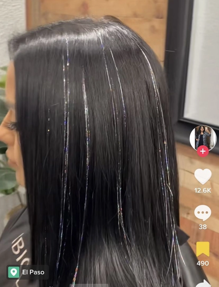 Festival hairstyle with shimmering hair tinsel woven into braids
