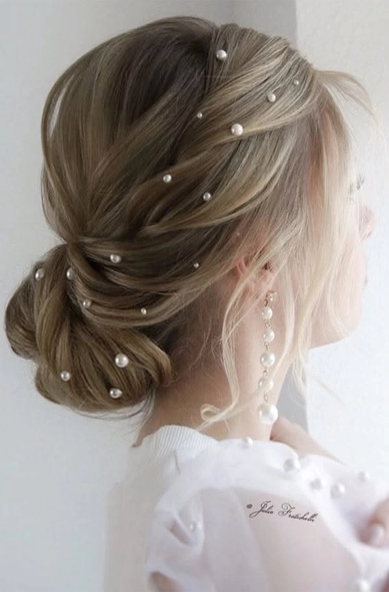 Pearl-embellished messy bun for a summer music festival Festival hairstyle with pearls woven into a braided updo